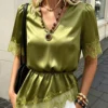 flora isola flora isola بلوزة نسائية كاجوال لعطلات الربيع/الصيف بياقة على شكل حرف v وتفاصيل دانتيل متباينة وحافة غير متماثلة بلون موحد وأكمام قصيرة 3