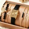 6 قطع مجموعة ساعات نسائية كوارتز، تشمل ساعة كوارتز بقرص أسود، سوار أوراق خرزي أسود، سوار دائري قلب، سوار مخطط مستطيل أسود، وسوار رمز اللانهاية. علبة ساعة ذهبية وردية مع سوار جلد pu أسود، تبرز أناقة الموضة الراقية وتؤكد الجودة العالية. 11