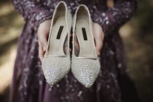 pexels photo 10282408 10282408 Woman in purple sequin dress holding sparkling high heels outdoors.