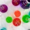 Aerial view of colorful liquids in laboratory glassware on marble surface, showcasing vibrant hues.